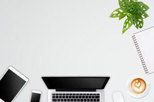 Modern workspace with laptop tablet, smartphone and coffee cup copy space on color background. Top view. Flat lay style. photo