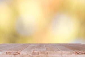 mesa de madera sobre fondo naranja bokeh - se puede utilizar para montar o mostrar sus productos foto