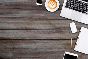 Modern workspace with laptop tablet, smartphone and coffee cup copy space on wood background. Top view. Flat lay style. photo