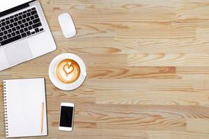 Top view laptop computer or notebook,mobile phone and cup of latte art coffee on wooden table. Business template mock up for adding your text. photo