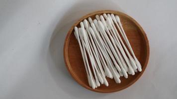 Pile of cotton buds on a wooden plate ready to use photo