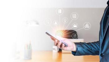 Concept of online data management. Businessman using smartphone to manage database on the internet, cloud storage, space saving, easy data editing, easy access, online business, modern business. photo