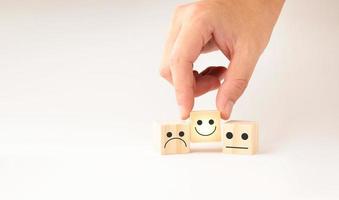 Customer service and Satisfaction concept ,Business people show a feedback with smile face wood cube happy Smiley face icon to give satisfaction in service. rating very impressed. photo