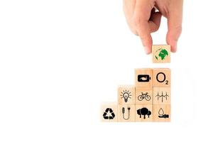 Ideas to save the environment for World Environment Day. hand picking up wooden blocks with Earth icon on top. energy saving, clean energy, reforestation, increase oxygen, reduce fuel consumption. photo