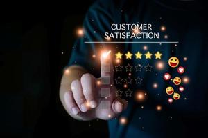 concepto de evaluación de la satisfacción del cliente, hombre que usa un teléfono inteligente sonriendo y con el pulgar hacia arriba, califica cinco estrellas, envía emoji y corazones sonrientes, cara sonriente satisfecha, excelente servicio, el cliente está feliz. foto