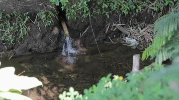 il fonte di molto pulito acqua flussi nel tubi fatto di bambù tipico di il indonesiano persone video