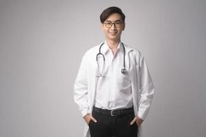 Portrait of male confident doctor over white background studio, healthcare and Medical technology concept. photo