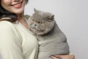 A young woman is holding lovely cat , playing with cat in studio on white background photo