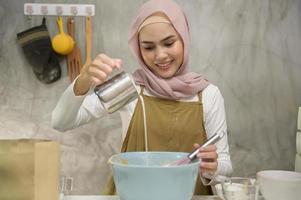 Young beautiful muslim woman is baking in her kitchen , bakery and coffee shop business photo