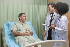 el médico caucásico está examinando y consultando a un paciente mayor en el hospital. foto