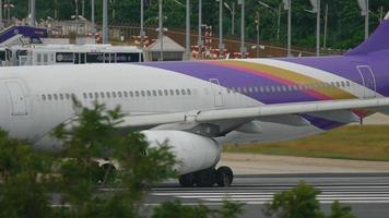 phuket, tailândia 26 de novembro de 2016 - thai airways airbus 330 hs tbd taxiando na pista antes da partida do aeroporto de phuket. video