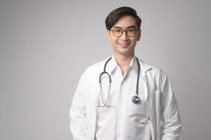 retrato de un médico de confianza masculino sobre un estudio de fondo blanco, concepto de tecnología médica y asistencia sanitaria. foto