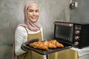 Young beautiful muslim woman is baking in her kitchen , bakery and coffee shop business photo