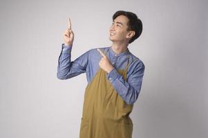 Portrait of young asian man wearing apron over white background studio, cooking and entrepreneur concept photo