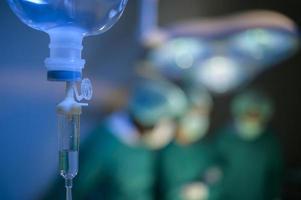 Group of mixed-races professional surgeons operating in hospital operating room , health care concept. photo