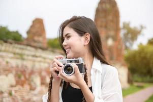 young beautiful woman traveling and taking photo at thai historical Park, Holidays and cultural tourism concept.