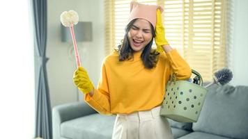 Young exhausted and tired housekeeper wearing yellow shirt in living room. photo