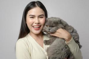 A young woman is holding lovely cat , playing with cat in studio on white background photo