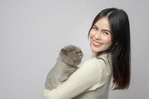 A young woman is holding lovely cat , playing with cat in studio on white background photo