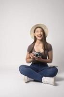 Young happy asian tourist woman over white background studio, travel and holidays concept. photo