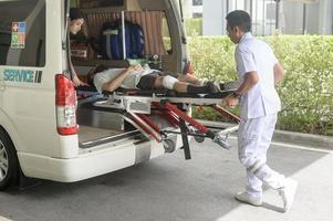 Group of rescue emergency team transporting patient from Emergency car  through Hospital Corridors. cardio pulmonary resuscitation on an unconscious patient . photo