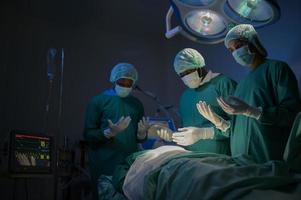 Group of mixed-races professional surgeons operating in hospital operating room , health care concept. photo