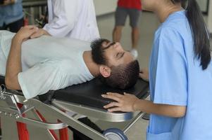 Group of rescue emergency team transporting patient from Emergency car  through Hospital Corridors. cardio pulmonary resuscitation on an unconscious patient . photo