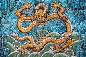 Yellow dragon with raised forepaws on the wall photo