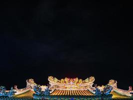 Roof of Chinese Temple under the night sky in bangkok City Thailand photo