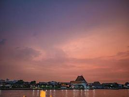 paisaje urbano de la ciudad de bangkok y el río chao phraya con una hermosa puesta de sol desde el paseo del río yodpiman en la ciudad de bangkok, tailandia foto