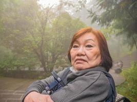 Portrait Senior asian women Wearing the hat on Zhangjiajie National Forest Park in Wulingyuan District Zhangjiajie City China in the Foggy day photo