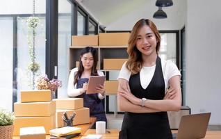 Portrait of Asian young woman SME working with a box at home the workplace.start-up small business owner, small business entrepreneur SME or freelance business online and delivery concept. photo