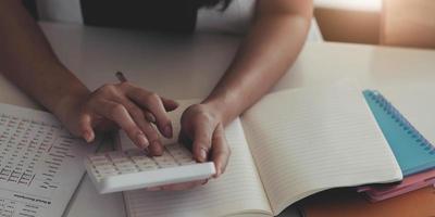 Close-up of business woman hands using a calculator to check company finances and earnings and budget. photo