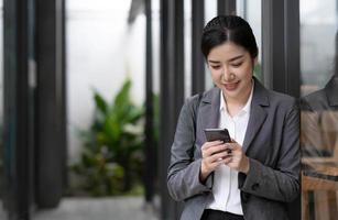 Portrait of a beautiful smiling woman using a mobile phone outdoors photo