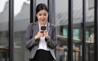 Portrait of a beautiful smiling woman using a mobile phone outdoors photo