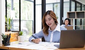 retrato de una hermosa mujer asiática de negocios sonriente que trabaja en una computadora de uso de oficina con espacio para copiar. propietarios de negocios personas sme freelance marketing en línea comercio electrónico telemarketing, concepto de trabajo desde casa foto