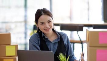Portrait of Starting small businesses SME owners, Asian woman check online orders Selling products online and working with boxs freelance work at home Asian sme business online small medium enterprise photo