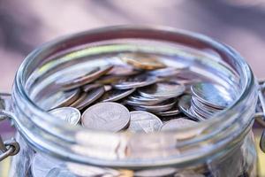 Many coins in glass jar, saving. photo