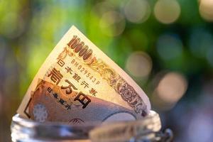 Japanese banknotes in glass jar. saving photo