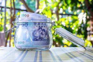 Taiwan banknotes in glass jar. photo