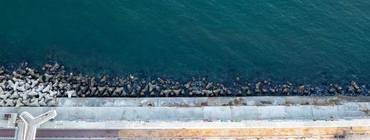 vista superior aérea desde el dron hasta la costa y el muelle de hormigón foto