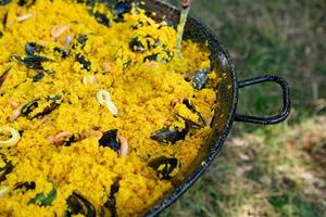 Paella traditional Spanish food. paella prepared on a large pan on the street on fire photo