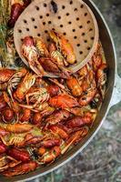 Boiled red crayfish or crawfish with herbs. Crayfish boiling in the pot on the fire photo