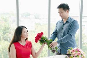 hombre dando ramo de rosas rojas con mujer foto