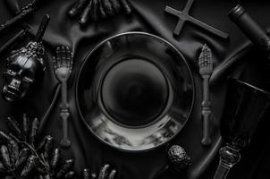 Halloween dinner party concept with black accessories, a bottle and glass of wine and grape fruits put on cloth background. photo