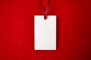 Modern advertising for cloth design. Clothes tag mock up white on red fabric. Modern design. Red fabric pattern background. Price tag. photo