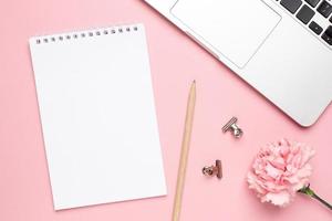 Notebook with pink carnation flower on a marble background photo