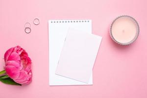 Beautiful pink peony flower and notebook with copy space for your text on pastel pink background photo