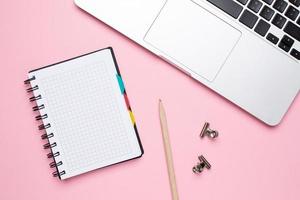 Notebook and laptop on a pink background photo