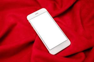 Black mock up mobile phone on red fabric background. Mobile app mockup. Smartphone blank screen, phone mockup. photo